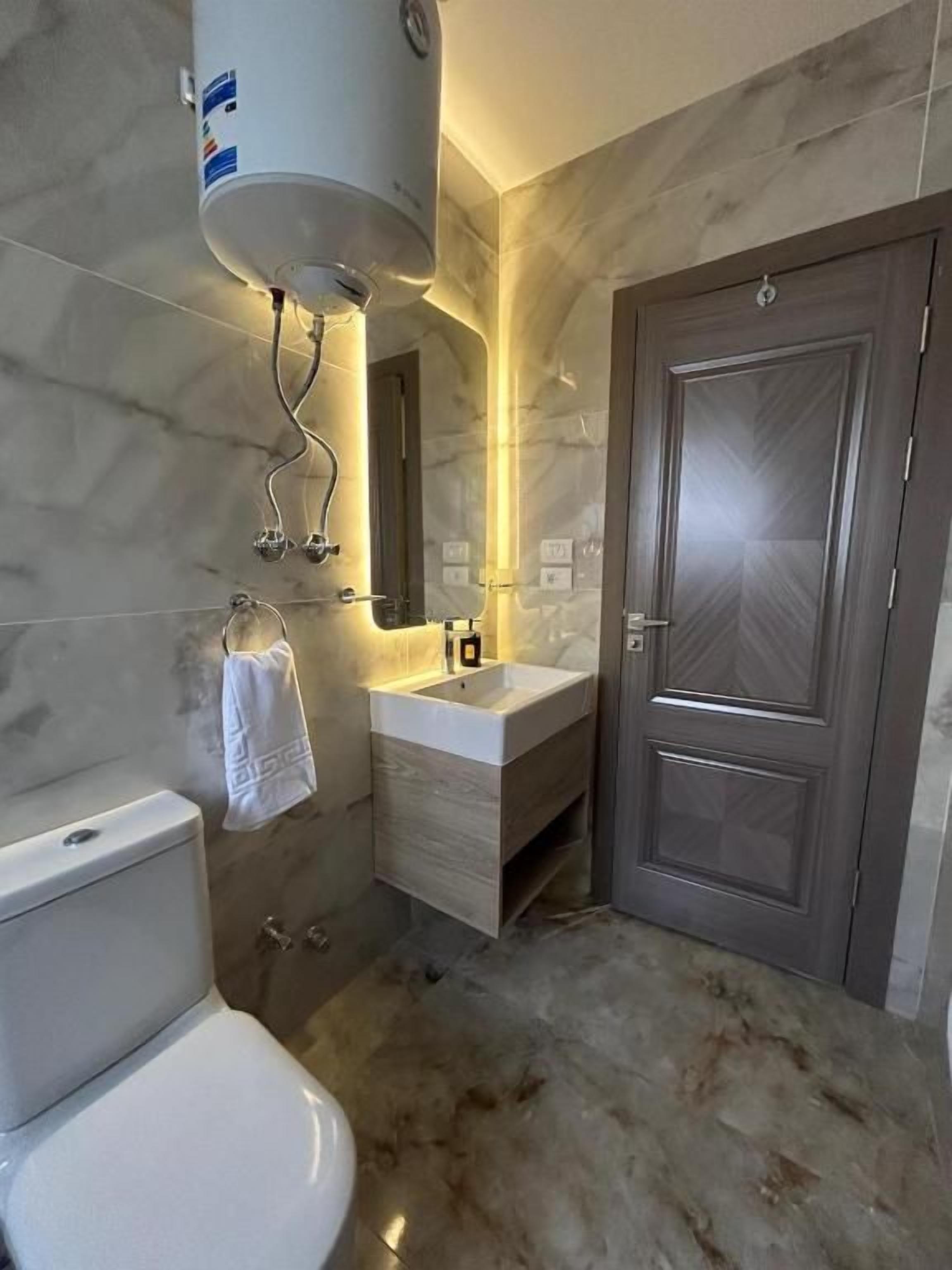 Un baño con inodoro, lavabo y zona de ducha.