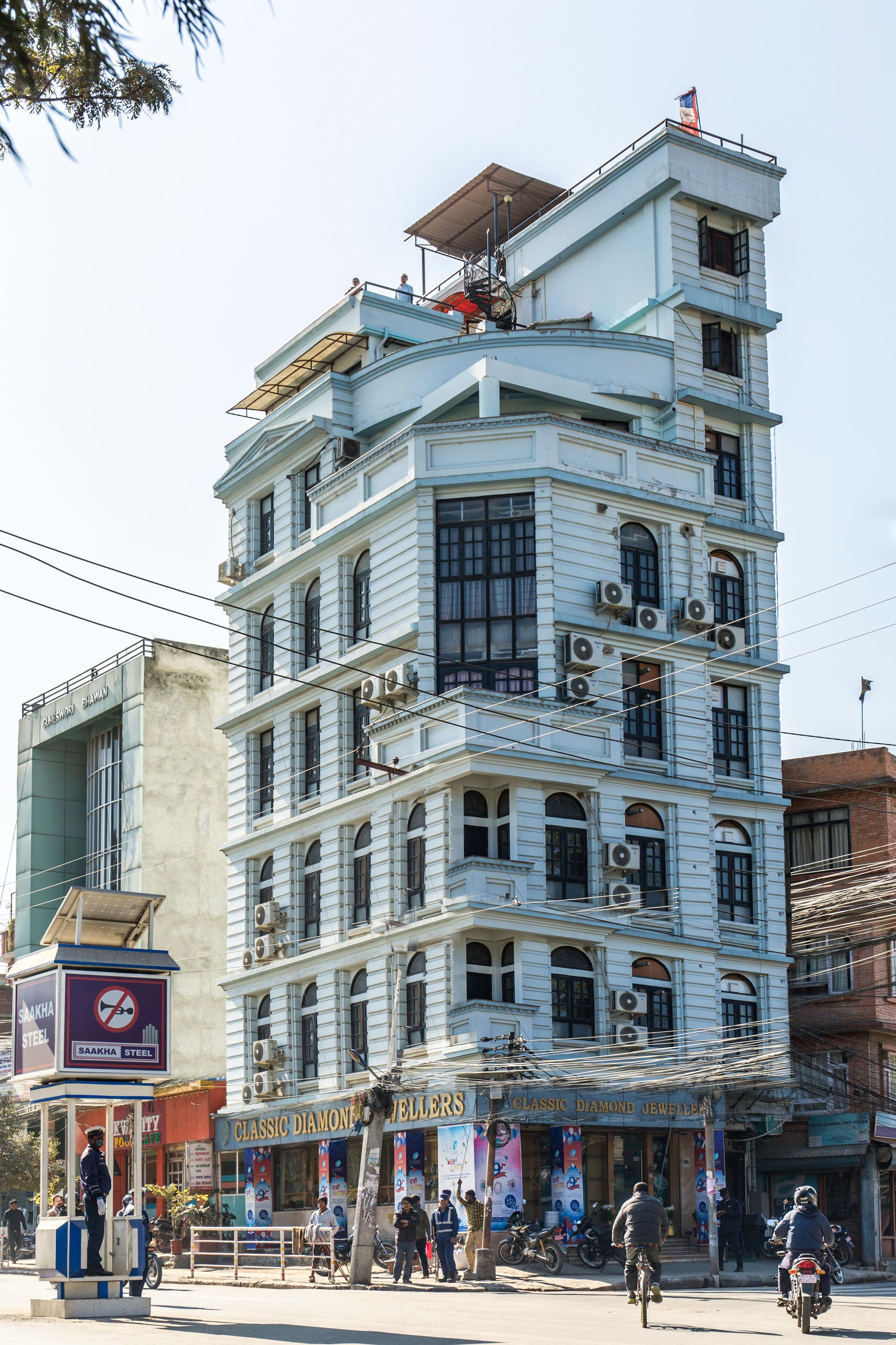 Un edificio de varios pisos con una mezcla de estilos arquitectónicos, incluyendo ventanas de arco y un techo plano.