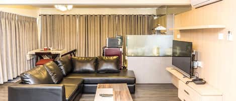 Una sala de estar moderna con un sofá modular, una mesa de centro y un televisor.
