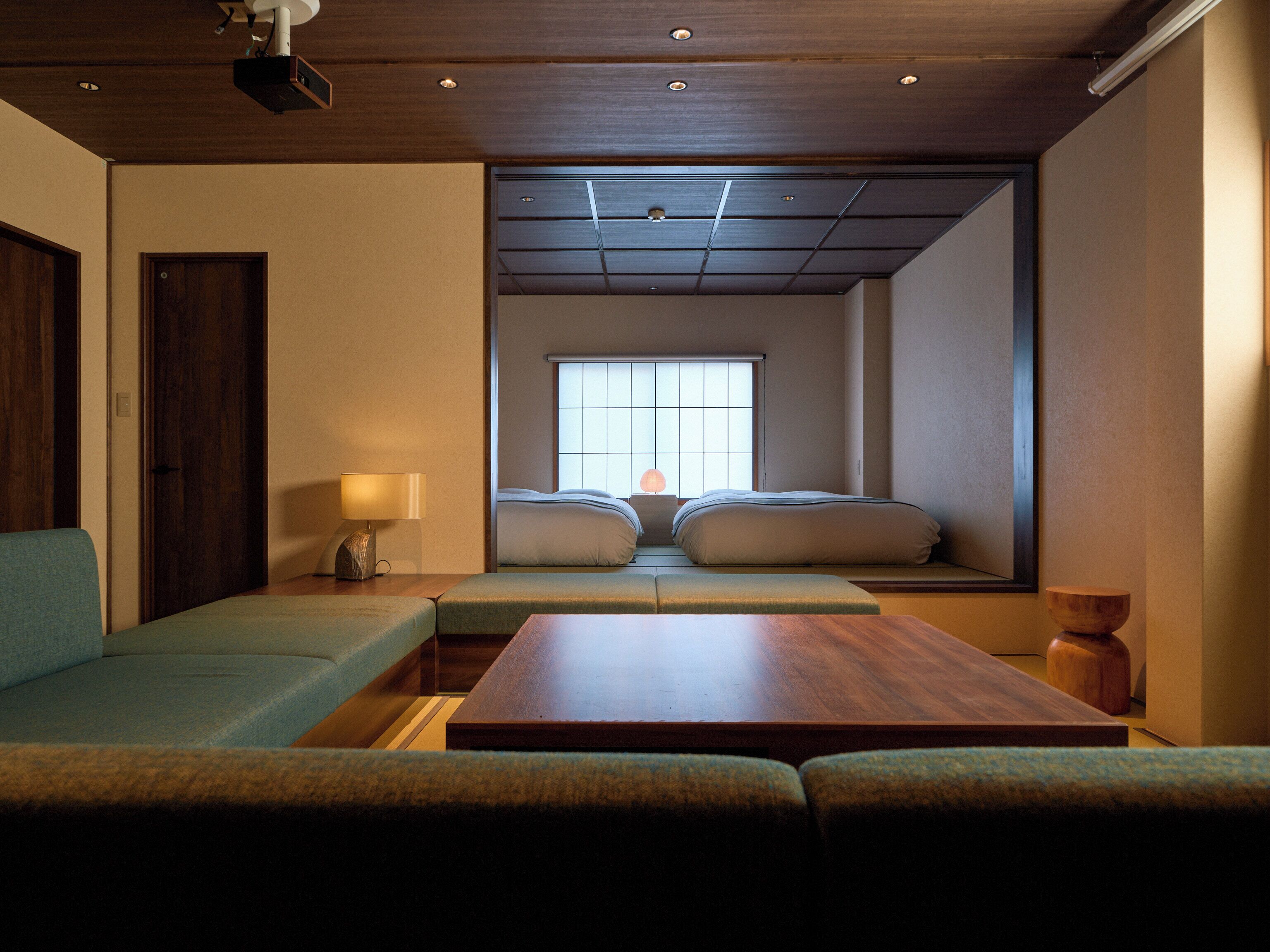 Una habitación con cama, sofá, mesa y ventana con vistas.