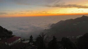 A mountainous landscape during sunrise or sunset with a view of the clouds below and a building on the left. - Rudrashray Paradise Mussoorie (Mussoorie)
