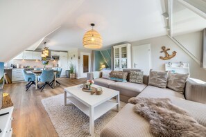 A modern loft apartment with a kitchen, dining area, and living room. - Modern 3-room vacation apartment with approximately 75 m² of living space, accommodating up to 6 people (Wenningstedt-Braderup (Sylt))