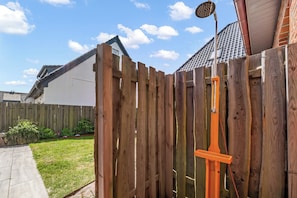 A wooden fence with a metal gate and a metal showerhead attached to it. - Modern 3-room vacation apartment with approximately 75 m² of living space, accommodating up to 6 people (Wenningstedt-Braderup (Sylt))