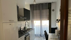 Een kleine keuken met een gasfornuis, oven en moderne kastjes.