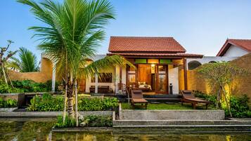 Un resort con piscina, zona de estar exterior y abundante vegetación.