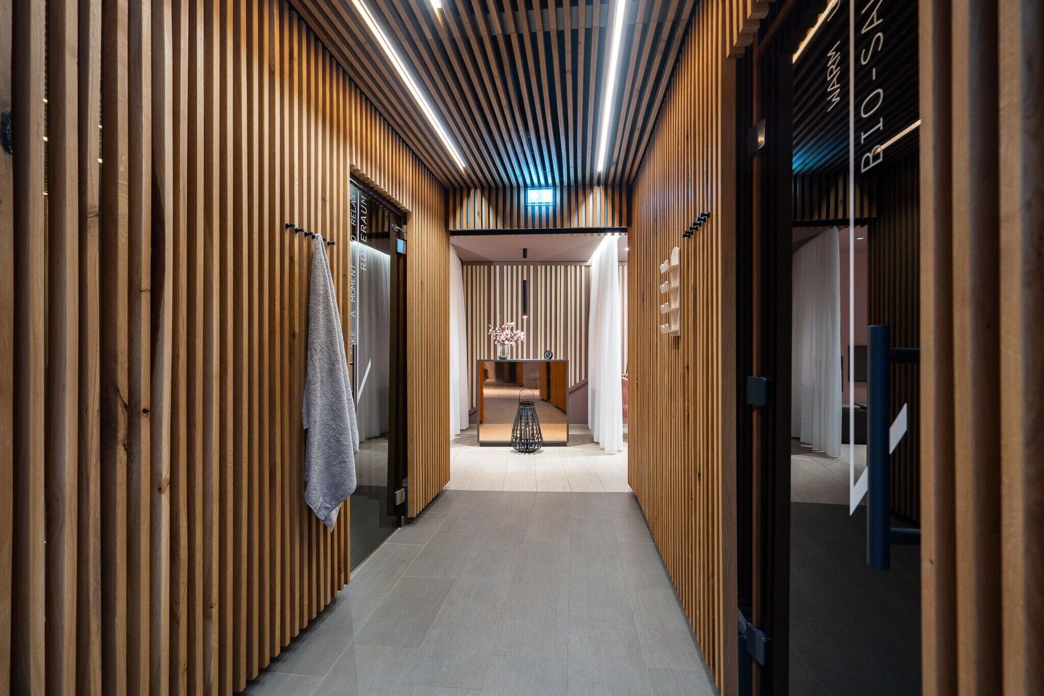 A corridor with wooden paneling, a reception desk, and a sign reading 'BIO-SAN.'