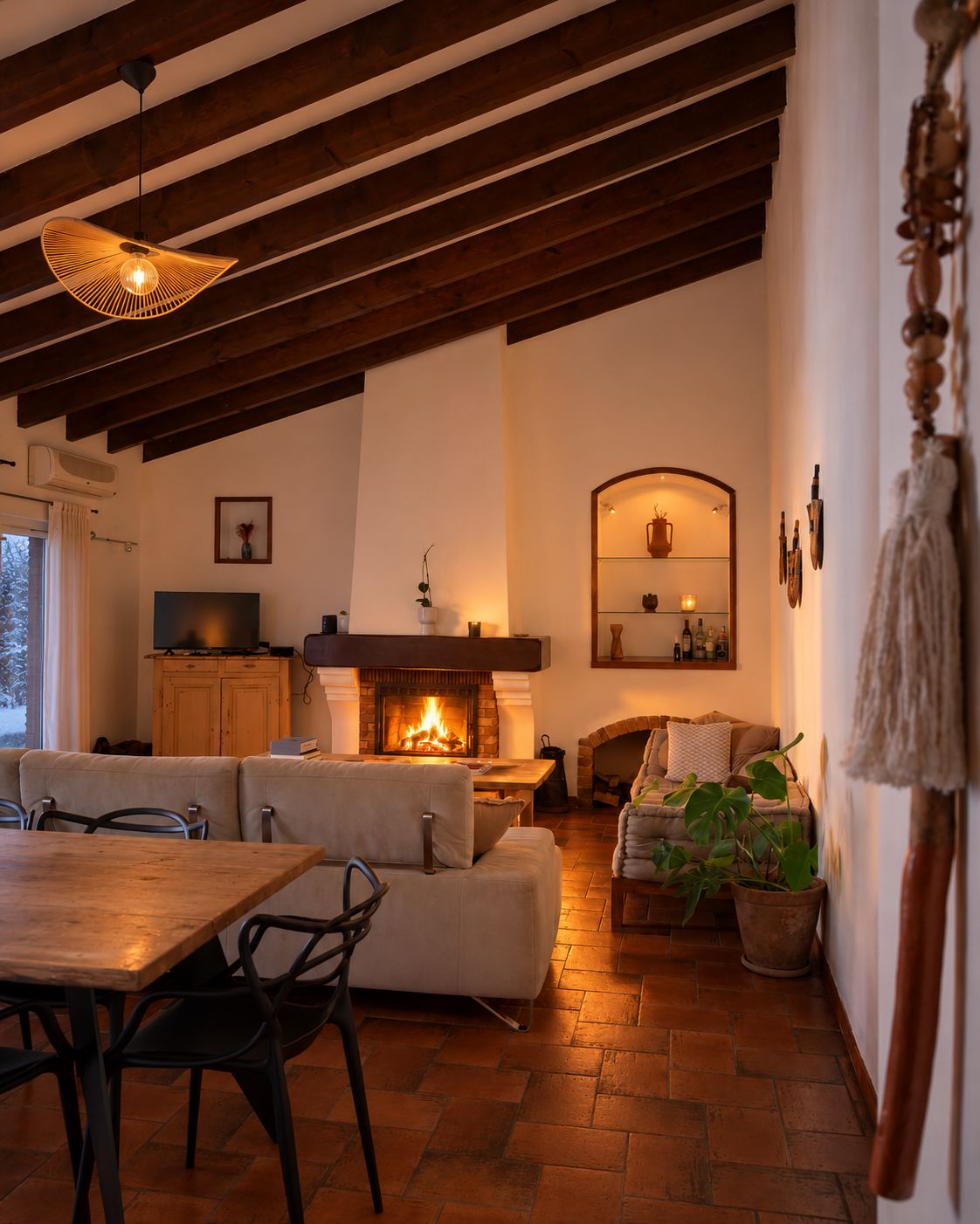 A cozy living room with a fireplace, a dining area with a wooden table and chairs, and a seating area with a sofa and armchairs.