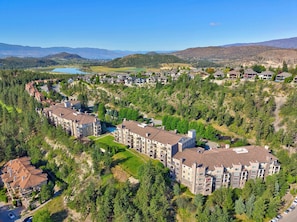 A residential area with multi-story buildings, a lake, and a hilly landscape. - Mountain View 2318 w Pool Hot-tub and Golf (Kelowna)