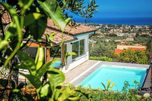 A pool with a clear view of the sea and a residential area in the background. - Sunlit gulffront villa with pool (Carini)