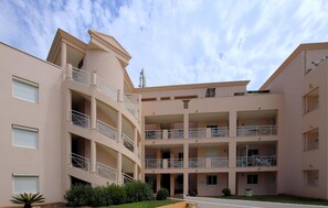 A multi-story building with balconies, a flat roof, and a clear sky. - 1 bedroom lovely apartment in Théoule sur Mer (Théoule sur Mer)