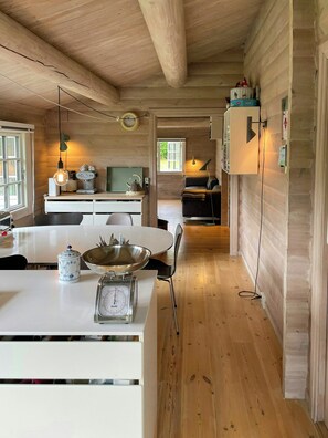 A wooden interior with a kitchen area featuring a white table, a kettle, a scale, and a bowl. - Beamed house by the water in Hornbæk (Hornbæk)