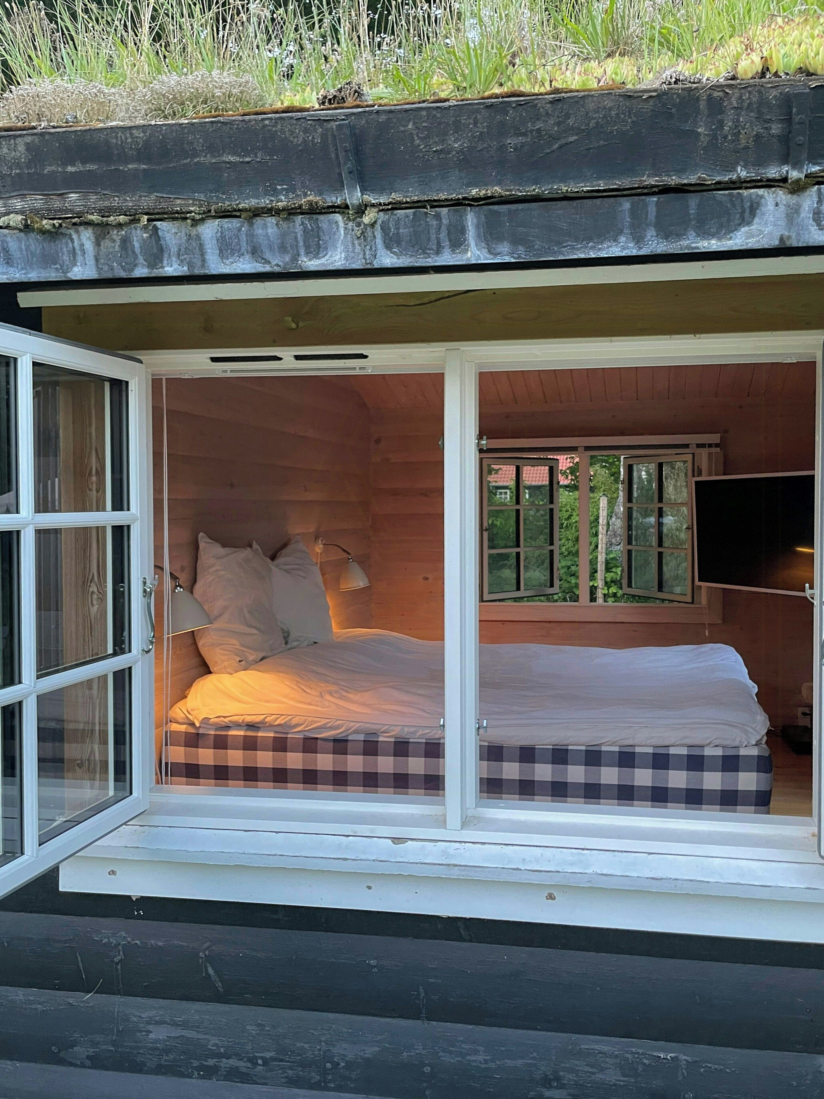 A cozy cabin with a bed, a window, and a view of the outdoors.