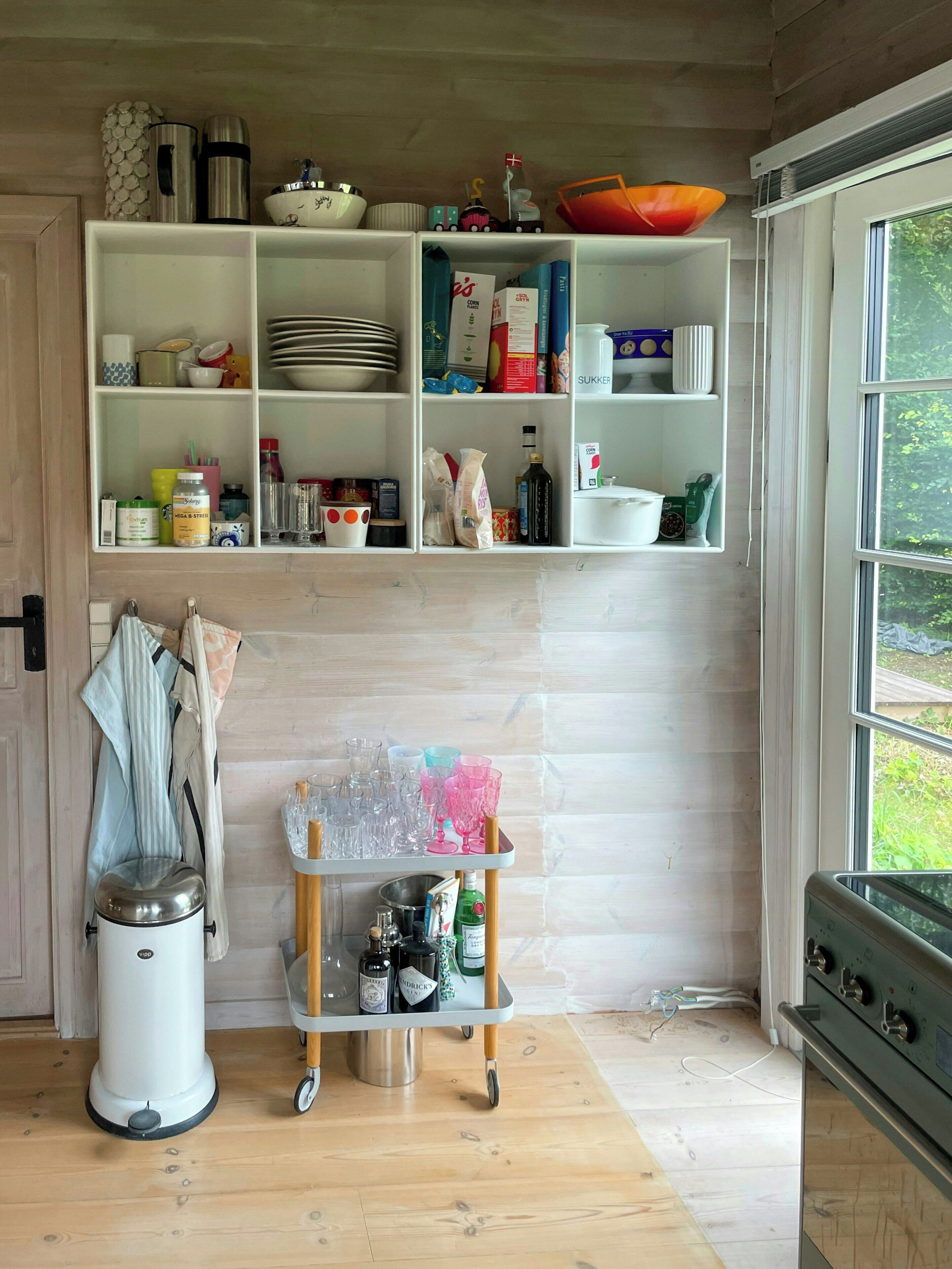 Una cocina con armarios de madera, una ventana y una encimera con varios objetos.