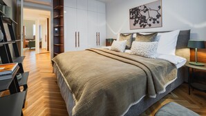 A modern bedroom with a large bed, a bedside table, a lamp, and a wardrobe. - My Second Home - Nekázanka 17 Residence (Hlavní město Praha)