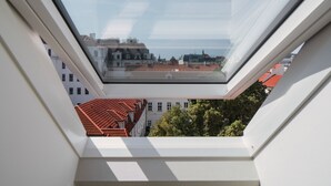 A skylight window with a view of buildings and trees. - My Second Home - Nekázanka 17 Residence (Hlavní město Praha)
