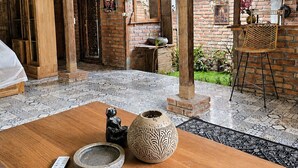 A rustic interior with exposed wooden beams, a brick wall, and a wooden table with decorative items.