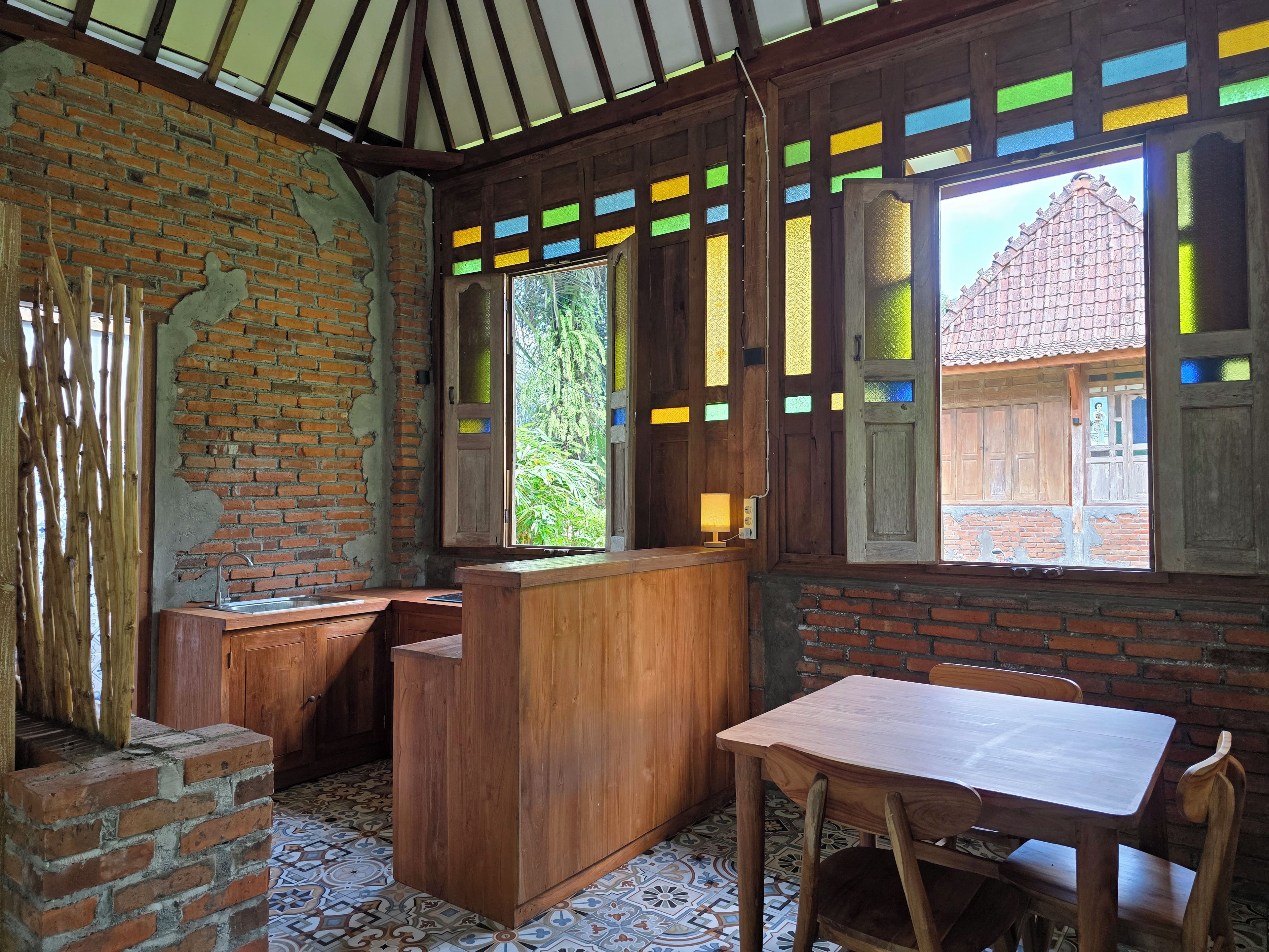 Ein rustikales Interieur mit freiliegenden Backsteinwänden, Holzmöbeln und einem Fliesenboden.