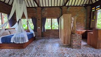 Une chambre avec un lit, un lavabo et une vue sur la verdure.