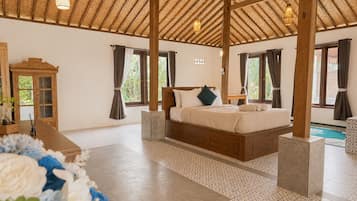 Una habitación amplia con una cama grande, techo de madera y vistas al exterior.