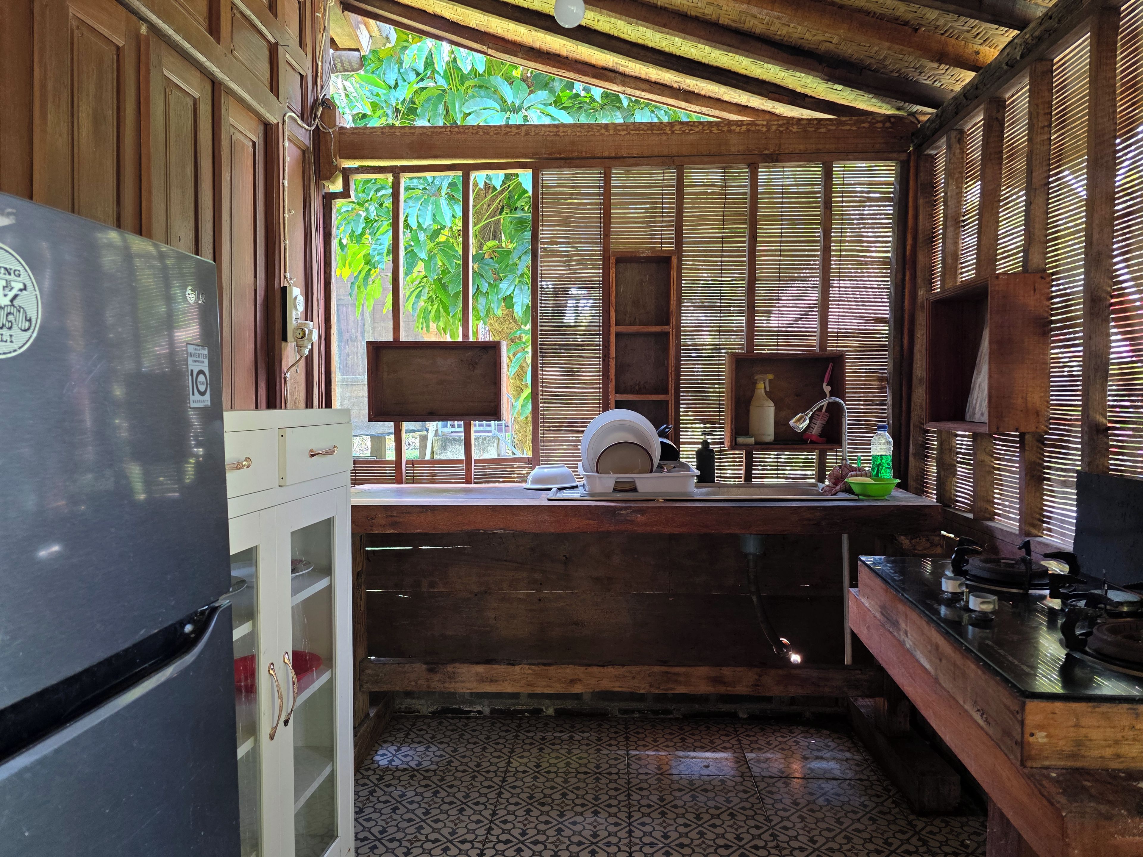 A compact kitchen with a refrigerator, sink, and stove.