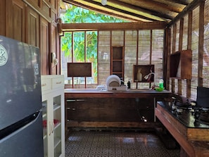 A compact kitchen with a refrigerator, sink, and stove.