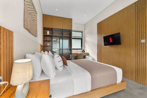 A modern bedroom with a bed, bedside table, lamp, and a TV mounted on the wall.
