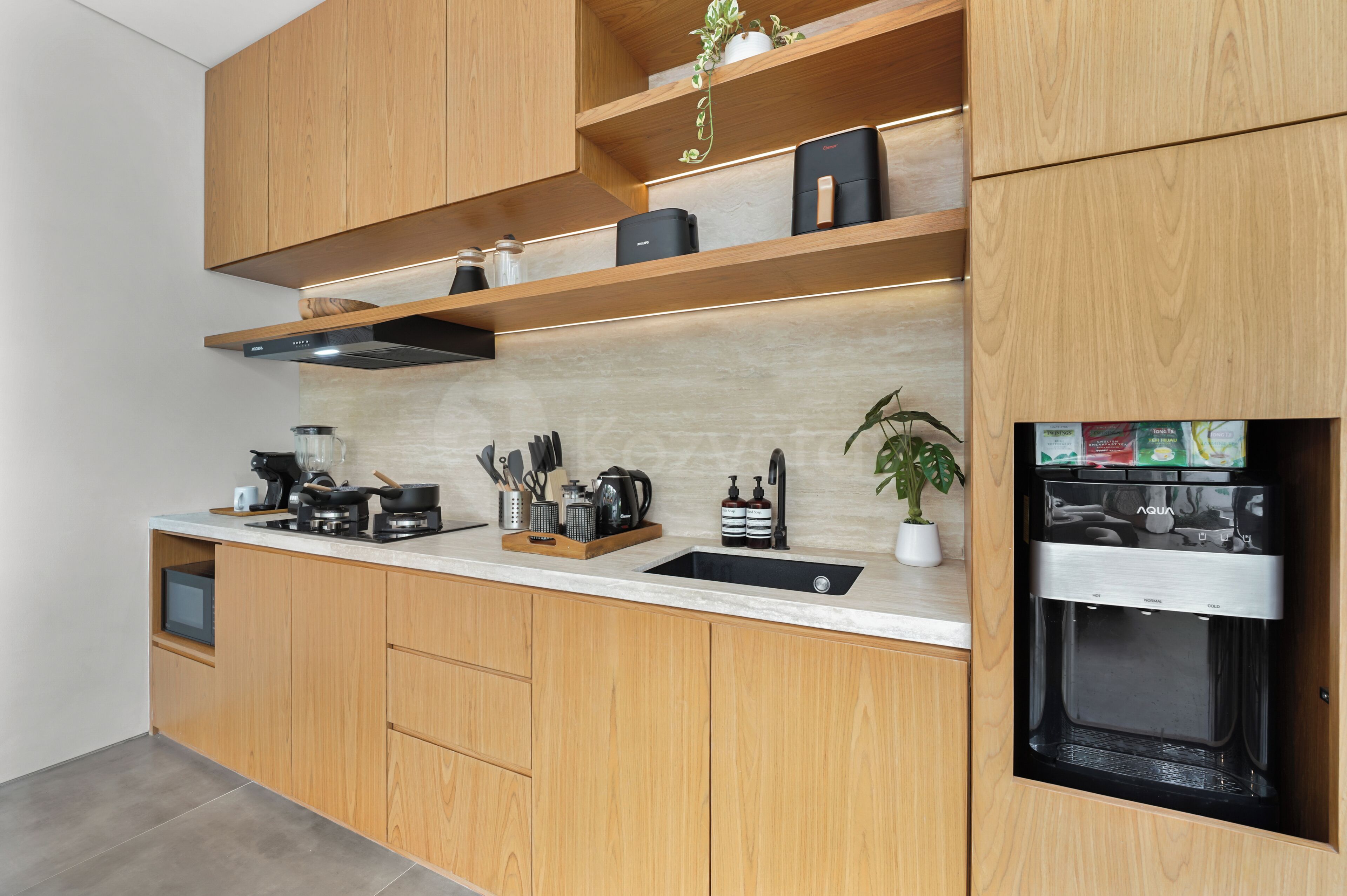 A modern kitchen with wooden cabinets, a built-in stove, and a black refrigerator.