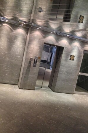 A metallic elevator with a glass door, a control panel, and a small sign on the wall. - Residenz Seehof 132 Appartement/Fewo, Dusche oder Bad, WC 3½-Zimmerwohnung by Interhome (Davos)