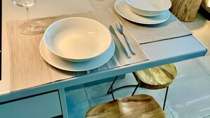 A dining area with a table set for two, featuring a white plate, a fork, and a knife. - Kalliopi's Apartment with Stunning Acropolis View (Athens)