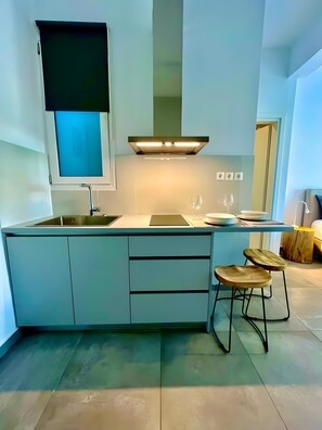 Uma cozinha moderna com ilha integrada, pia de aço inoxidável e banquetas.