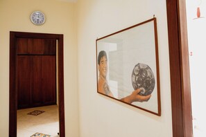 A hallway with a wooden door and a framed picture on the wall. - IN THE HISTORIC CENTER: A WONDERFUL APARTMENT EQUIPPED WITH ALL THE AMENITIES AND SERVICES (Napoli)