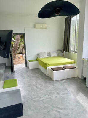 A modern bedroom with a bed, a TV, a ceiling fan, and a window with curtains. - Ibiza | Salinas Garden Cottage | Sleeps 4 (Sant Josep de sa Talaia)
