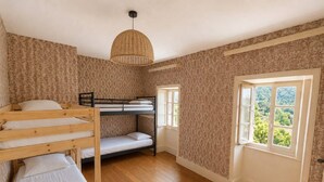 A room with a bunk bed, a single bed, a window with a view, and a woven light fixture. - Country house in the heart of the Ardèche, near Valence, with mountain views (Saint-Laurent-du-Pape)