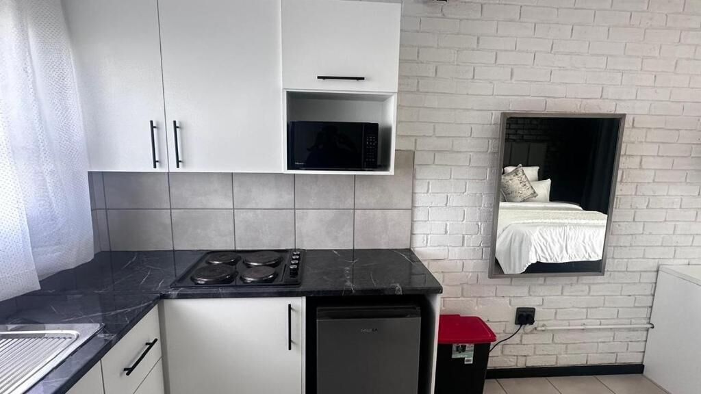 Frigorífico pequeño, microondas, placa de cocina y utensilios de cocina