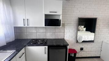 Frigorífico pequeño, microondas, placa de cocina y utensilios de cocina