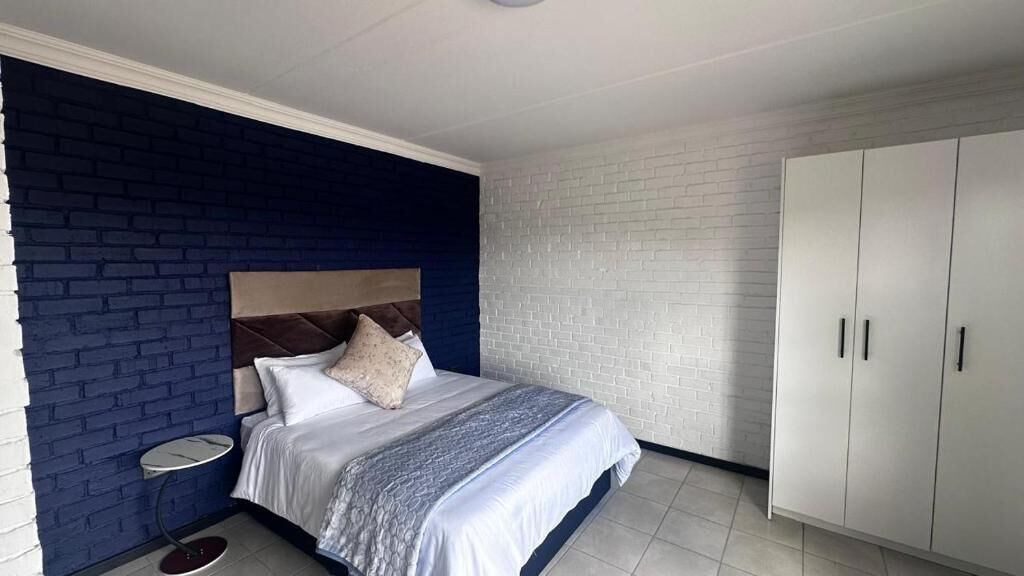 Un dormitorio con cama, mesita de noche y armario.