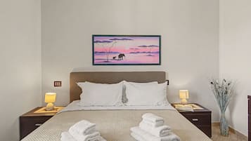 Una camera da letto con un letto, due lampade da comodino, un comodino con una lampada, un quadro appeso al muro e un vaso con piante.