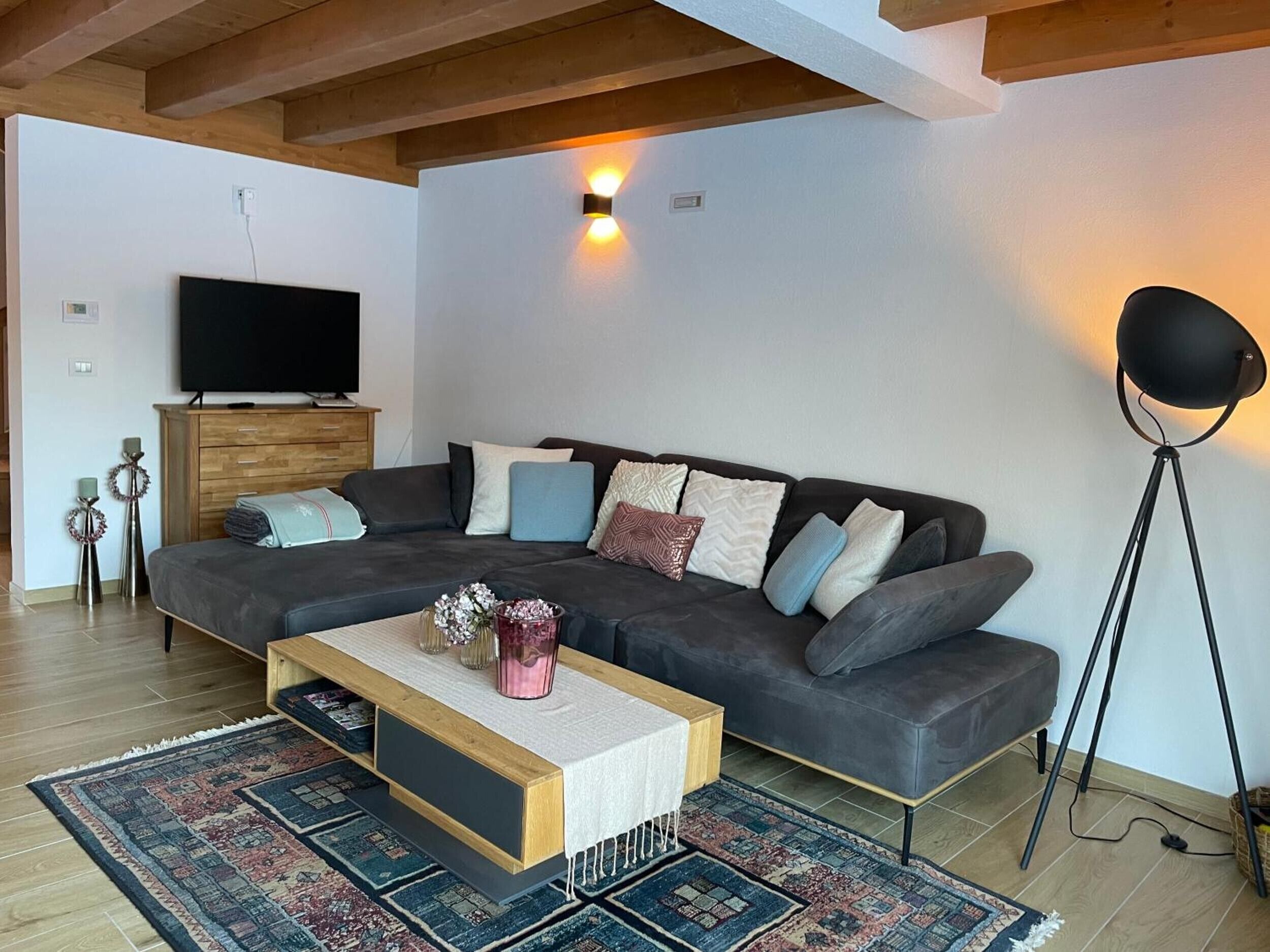 Ein modernes Wohnzimmer mit Sofa, Couchtisch und Stehlampe.