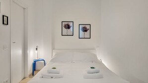 A hotel room with a bed, two wall-mounted pictures, a bedside table with a lamp, and a blue chair. - [Il Parco Apartment 6] Natura & Relax-RoadTo5Terre (Beverino)