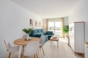 Un espace de vie moderne comprenant un coin repas, un canapé et une cuisine.
