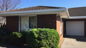 Ein Wohnhaus mit Garage, Ziegelhaus und gepflegtem Vorgarten.