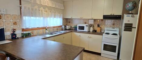 A kitchen with a central island, a microwave, an oven, and a stove.