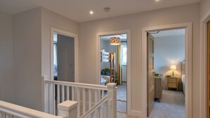 Une chambre d’hôtel avec un escalier, un lit, une table de chevet et une lampe.