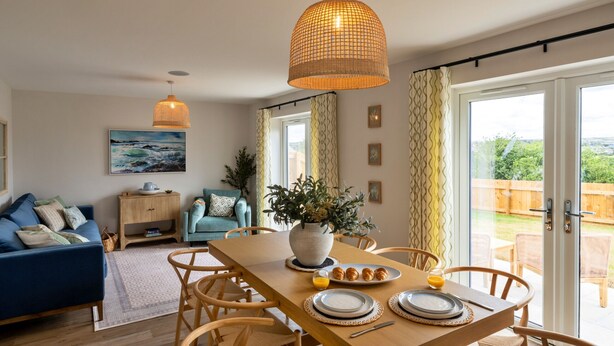 Un espace repas comprenant une table en bois, des chaises et un luminaire suspendu.