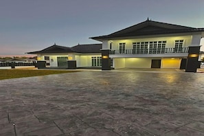 A two-story building with a balcony, a paved entrance area, and a well-lit facade. - MA Homestay: Comfortable Stay for Families & Groups (Marang)