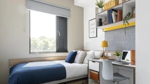 A bedroom with a bed, desk, chair, and a window. - Student Only Riverside (Canterbury)