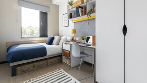 A bedroom with a bed, desk, chair, and a window. - Student Only Riverside (Canterbury)