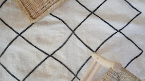Una cesta tejida sobre una superficie con un diseño de cuadrícula.