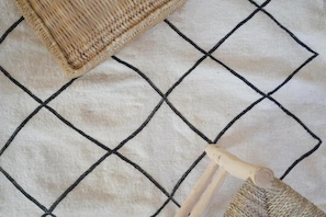A woven basket on a textured surface with a grid pattern. - Moana Surf Maroc (Aourir)
