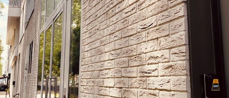 A building facade with a brick wall and a door labeled 'COLONIE SECHE'.